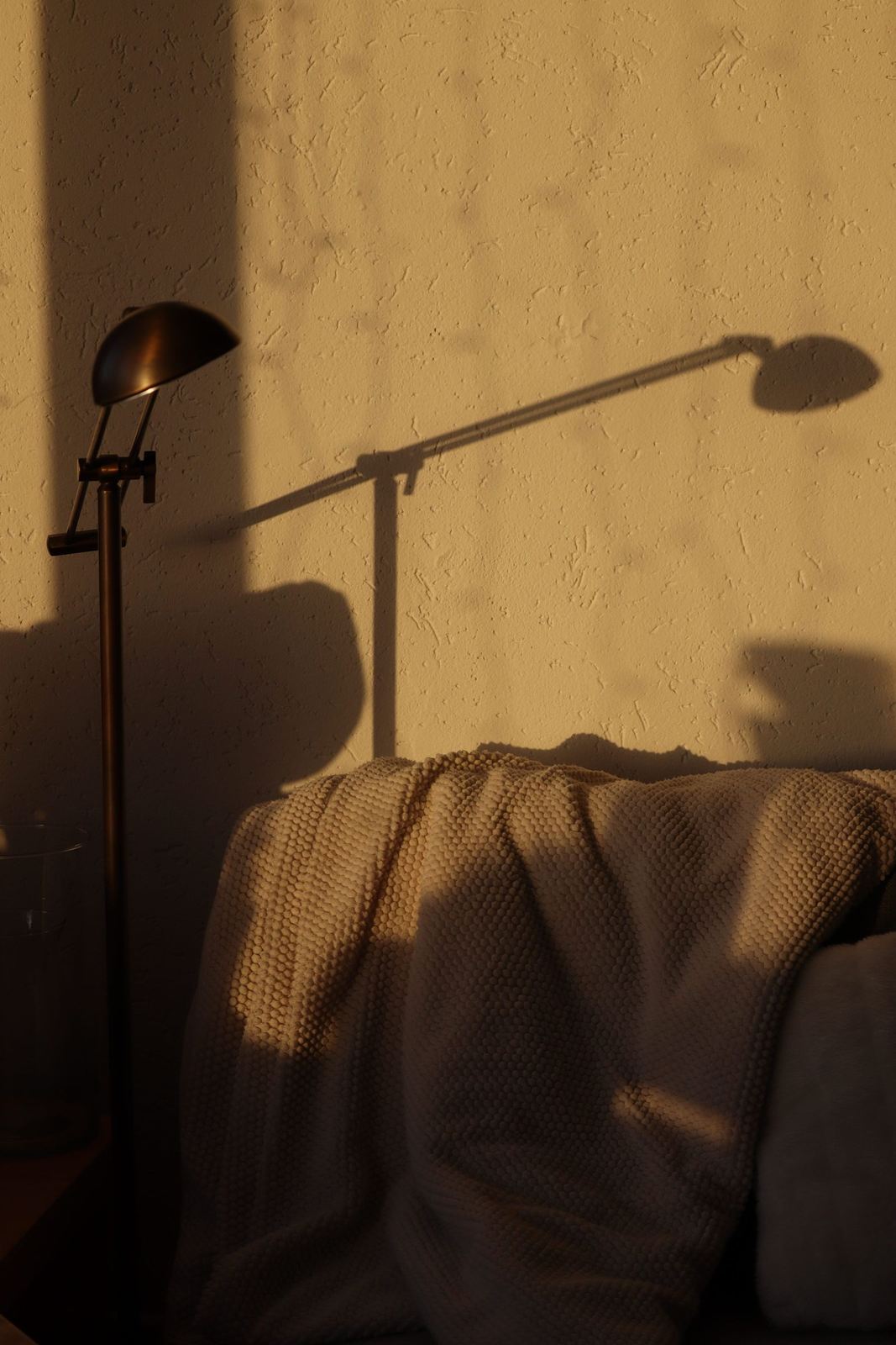 Warmes Licht einer Leuchte neben einem Sessel im Wohnraum