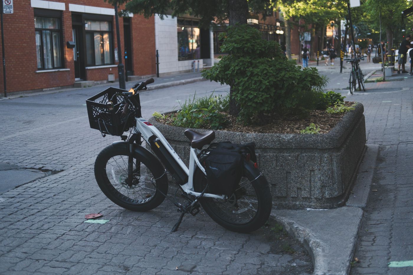 Elektrisch unterstütztes Fahrrad mit Korb und Taschen in einer Straße