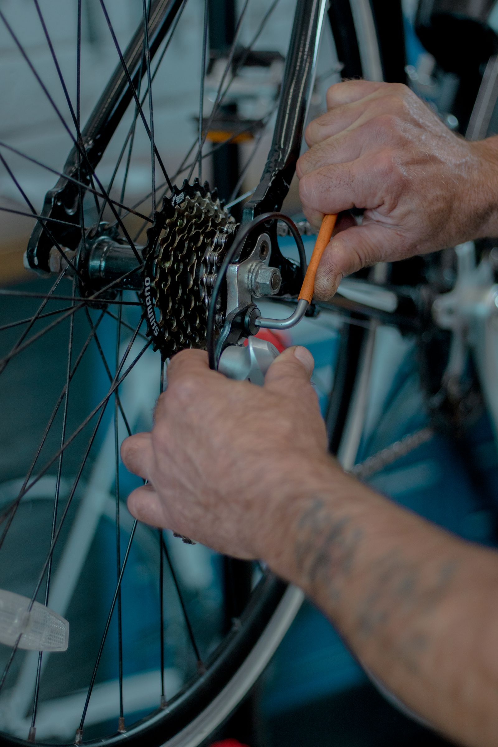 Hände bei der Reparatur von Fahrradschaltung und Hinterrad