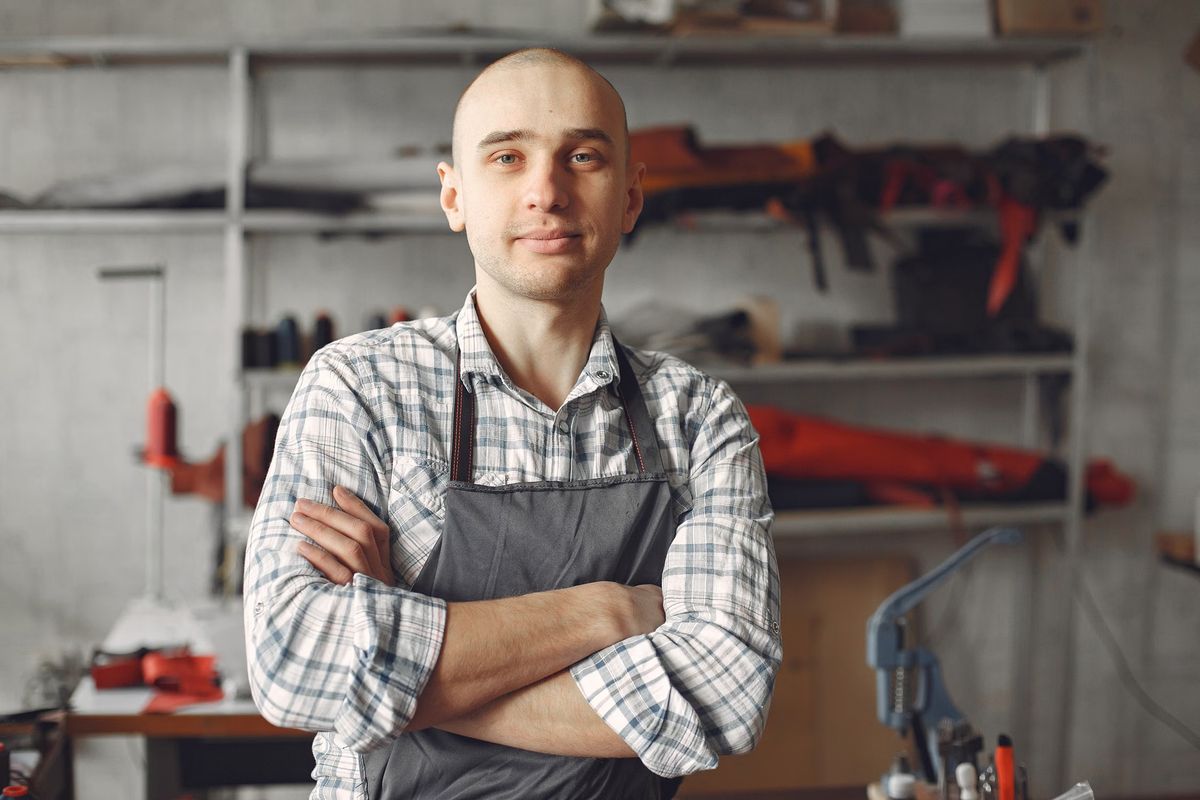 Stockfoto: Mann mit Schürze in einer Werkstatt